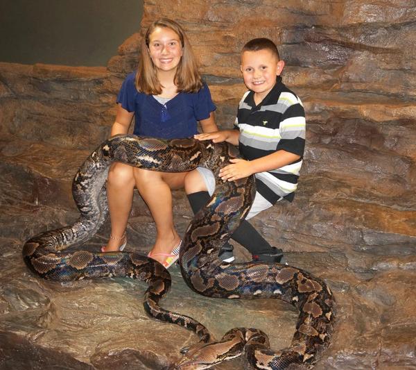 Kids at a NERD party holding a large python in The Cave
